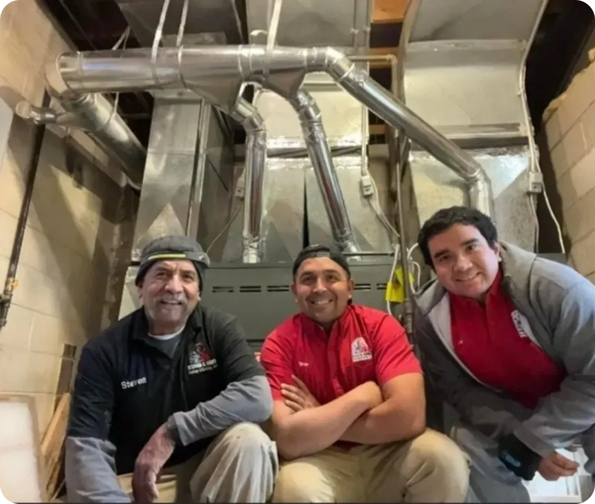 Smiling technicians posing in HVAC room