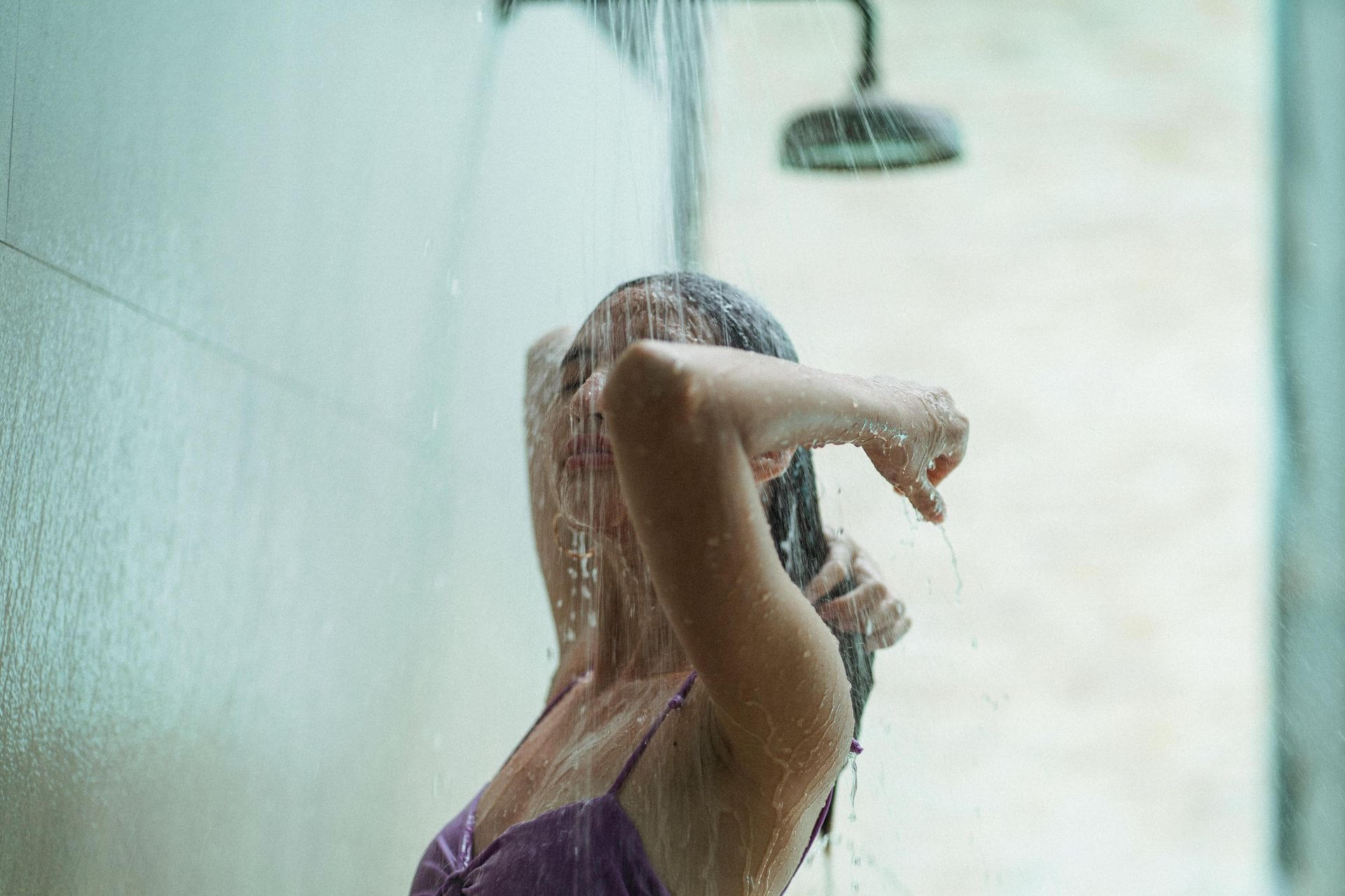 Person enjoying outdoor shower in swimwear