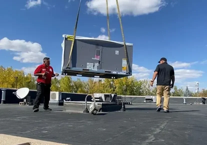 Workers guiding rooftop installation